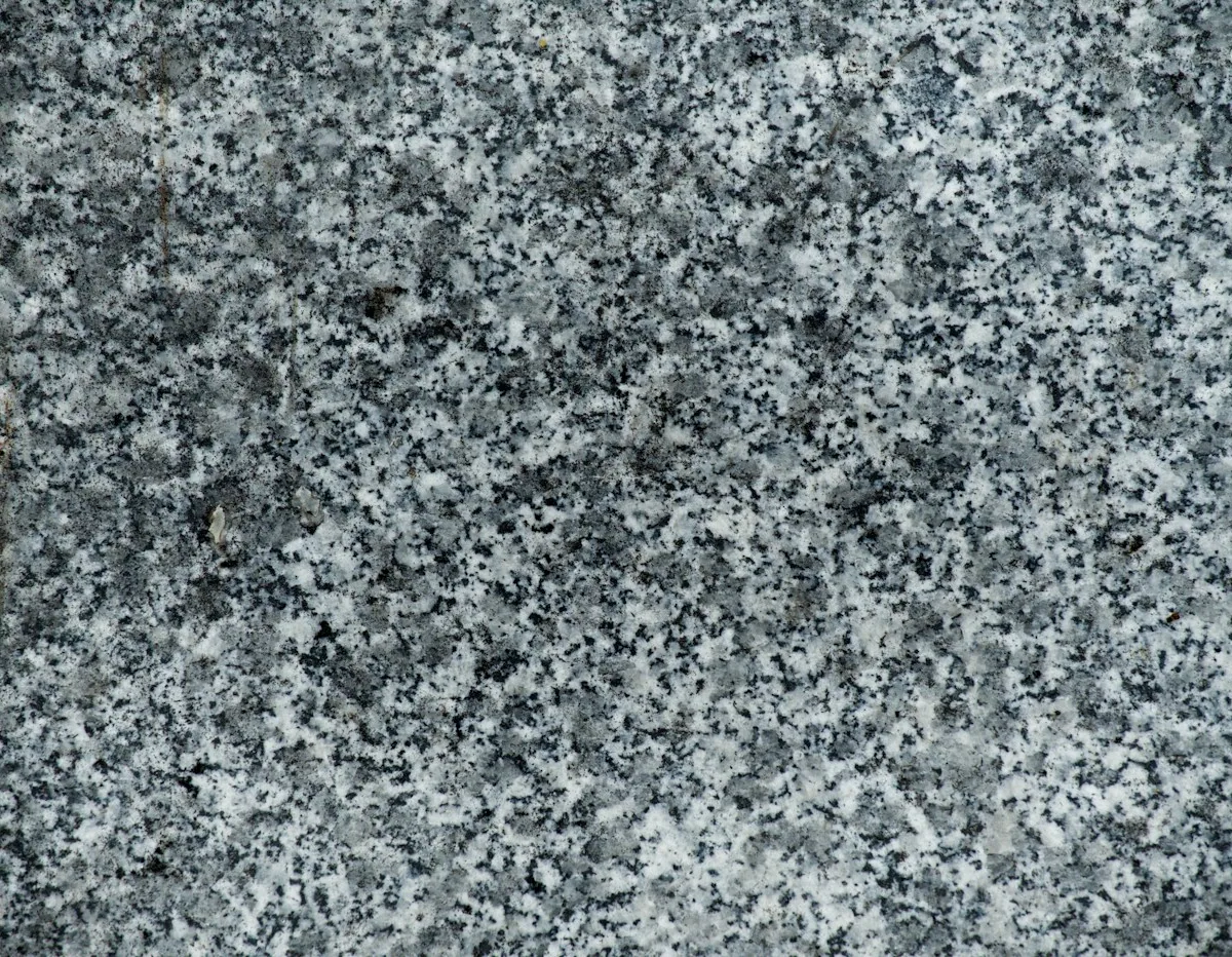 Närbild av grå, finkornig granit med ljusa och mörka mineralkorn
